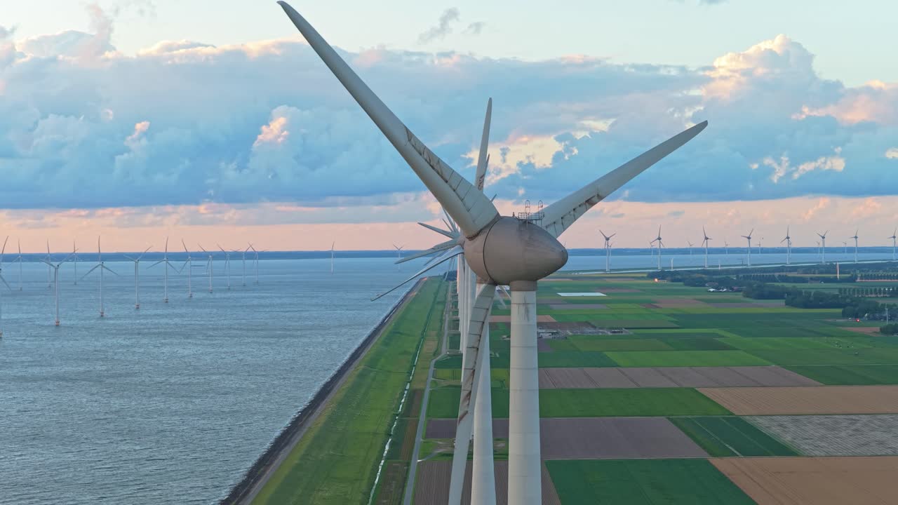 Dronebillede af vindmølle ved vandet, miljøvenlig polderenergi, Holland