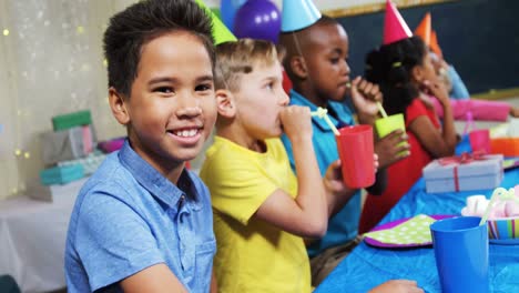 Portrait-of-boy-sitting-with-friends-during-birthday-party-4k