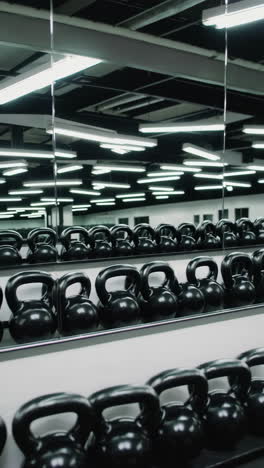 rows of black kettlebells in a modern gym