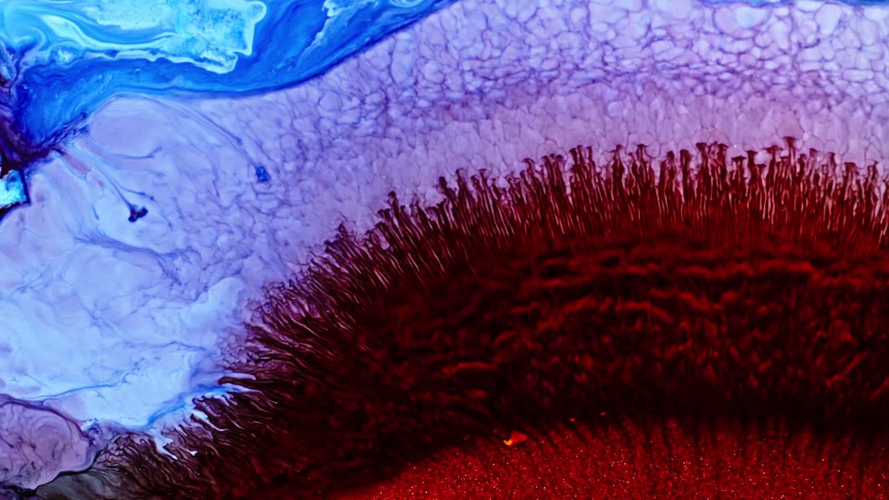 difusión de tinta azul y roja abstracta en el agua con un patrón vibrante y orgánico, que sugiere creatividad o un concepto científico