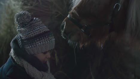 little girl preparing straw for pony