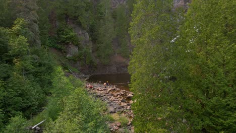 Beautiful-hidden-waterfall-in-North-Minnesota-with-people-visiting-it,-summer-vacation-places-to-go