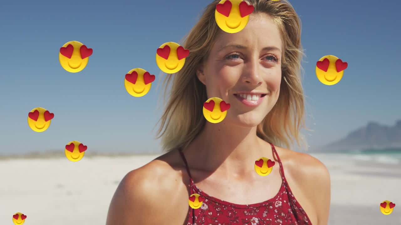 animación de emojis de amor de corazón rojo iconos digitales sobre mujer sonriente en la playa