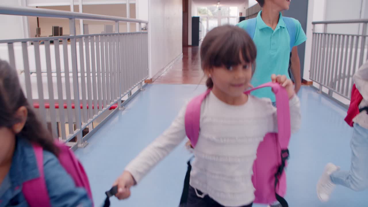 grupo diverso de escolares de diferentes edades corriendo en el pasillo, entre casilleros