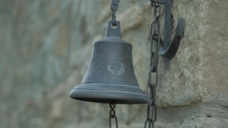 an ancient bell next to a castle in slow motion