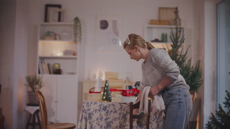 woman putting christmas stockings on chair