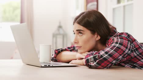 Mujer-Agotada-Usando-Una-Computadora-Portátil-Mientras-Toma-Café.