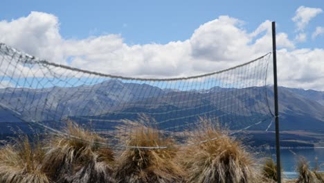 volleyball net waving in a fresh alpine breeze in front of bushes and mountain range