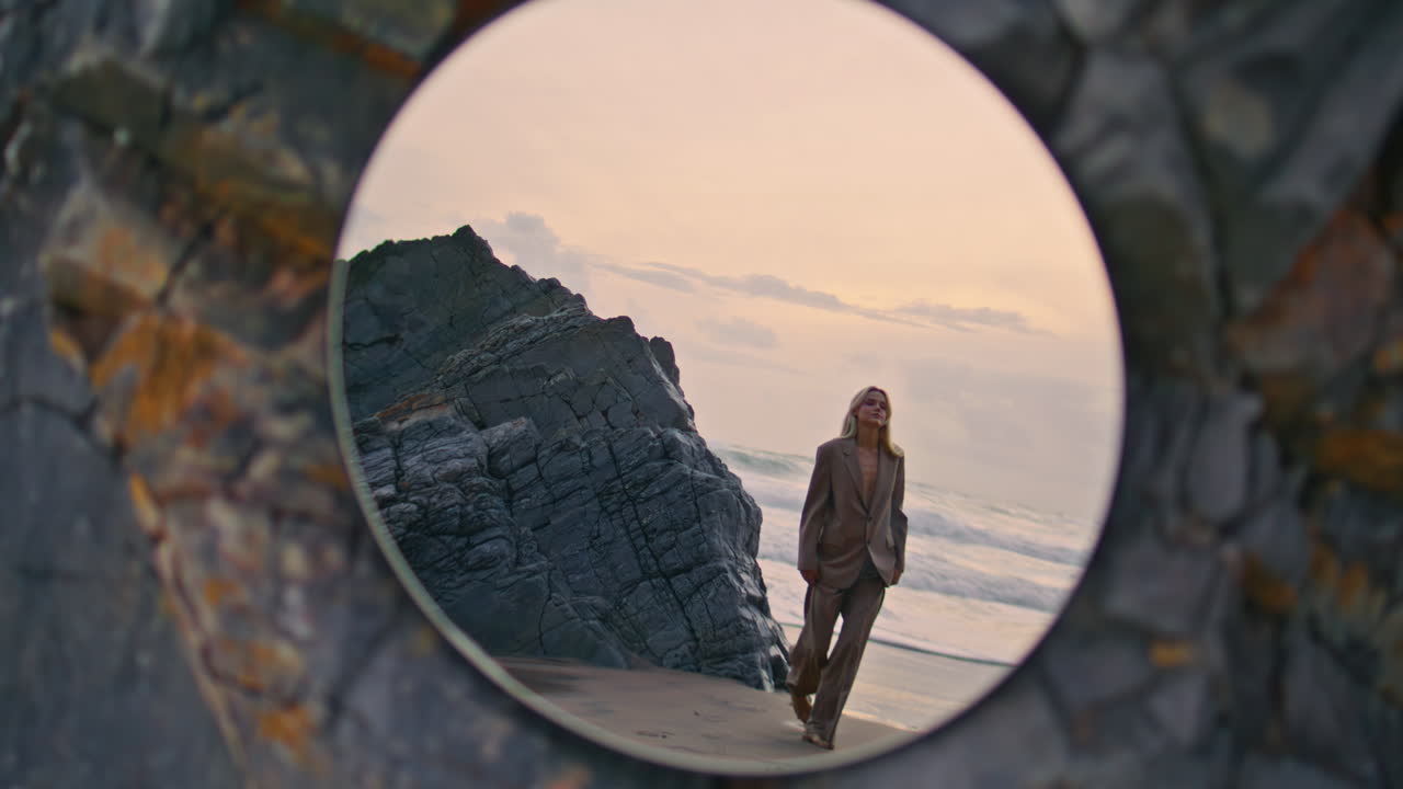 Woman stepping sunset beach in mirror reflection. Amazing evening sky at ocean