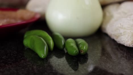 cerca de chiles verdes sobre una encimera de mármol