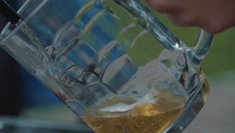 young man pours beer into a mug from a tap