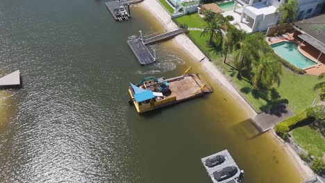 barge operates on river near residential area