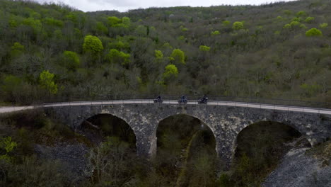 three quad bikes driving through an old bridge in central istria, croatia, europe during the day