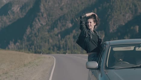 mujer expresa alegría y placer sentada en la ventana del coche