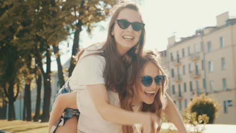 two friends having fun on a piggyback ride in the city