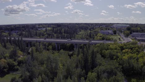 aerial-hold-over-international-concrete-bridge-with-worldwide-country-flags-on-posts-as-the-cumulus-clouds-change-formation-over-the-road-as-vehicles-cross-on-a-hot-sunny-day-over-a-park-flag2-2