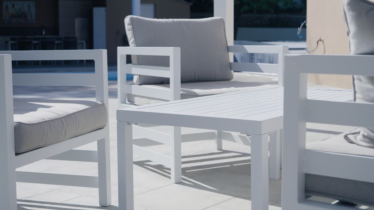 muebles de jardín en una terraza con su sofá y bancos de madera con sol