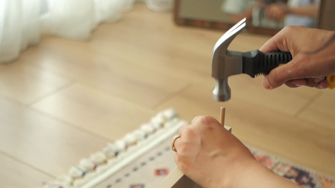 Hammering a nail into furniture