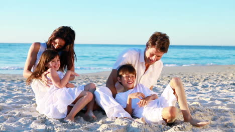 family sitting on the sand