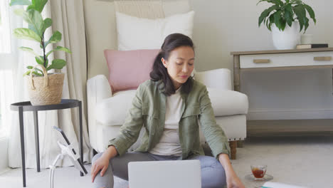 Mujer-Asiática-Feliz-Usando-Tableta-Y-Teléfono-Inteligente-En-El-Dormitorio,-En-Cámara-Lenta