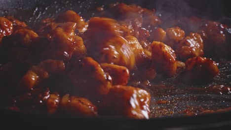 Mischen-Von-Süß-saurem-Hähnchen-Mit-Soße-In-Einer-Pfanne-Mit-Einem-Holzlöffel,-Nahaufnahme