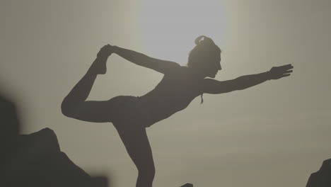 woman practicing yoga outdoors at sunrise
