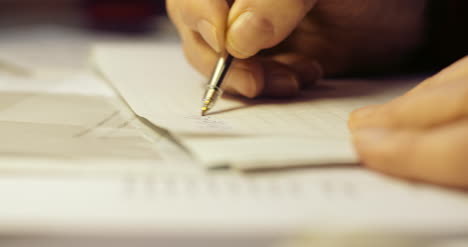 Senior Businessman Writing On Paper At Table In Office 33