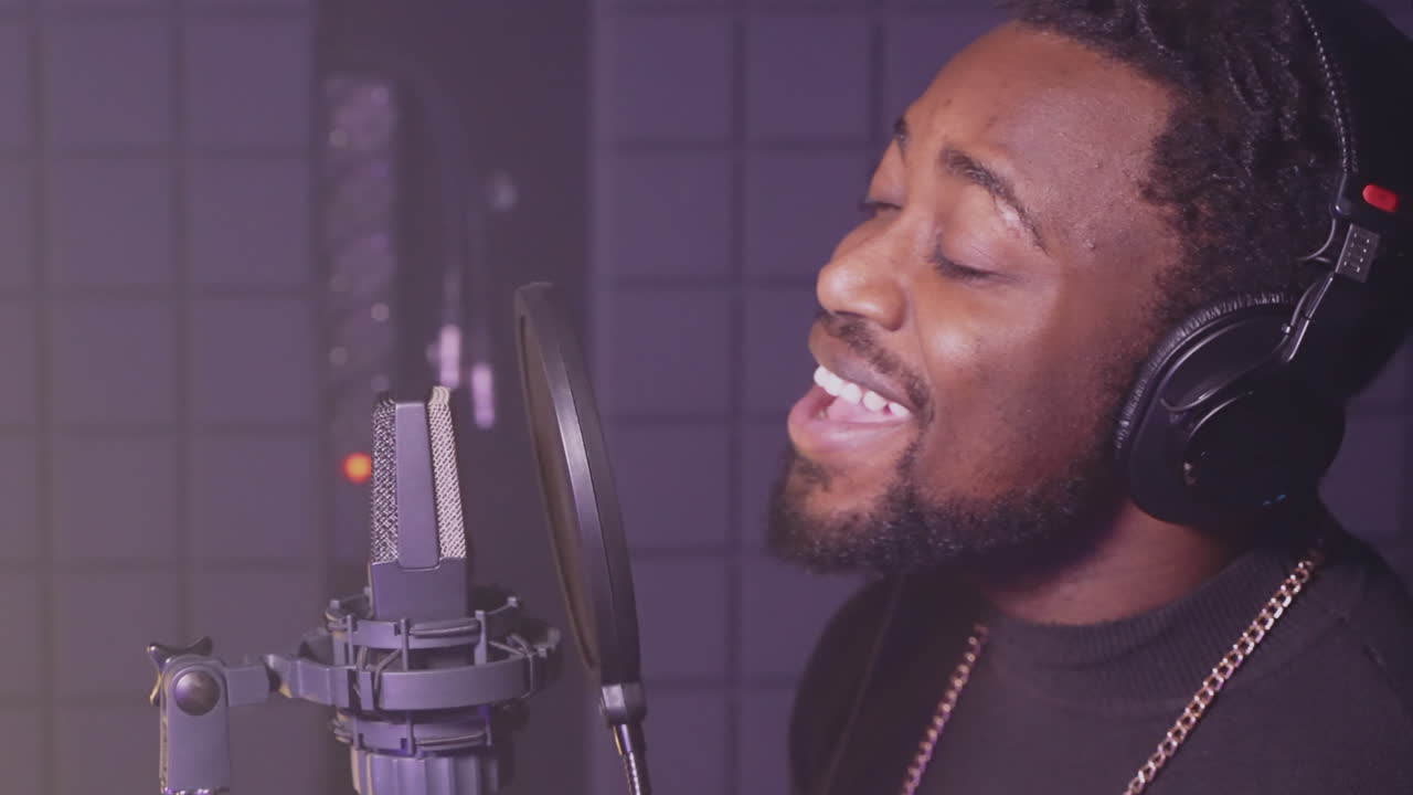 Man Singing into a Microphone in a Recording Studio