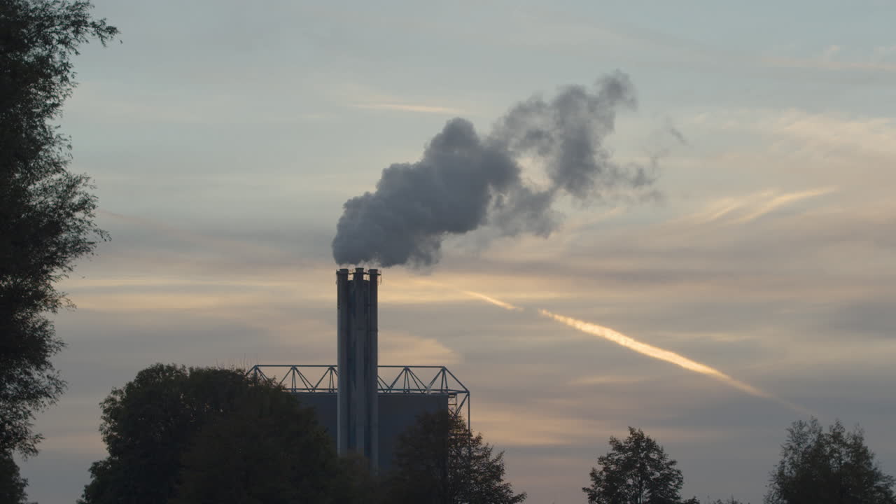chimenea de fábrica humeante al atardecer - cámara lenta de 120 fps