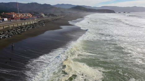 aerial view flying over waves at the sharp park beach in sunny pacifica, usa