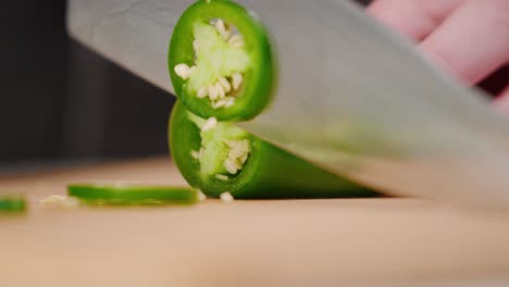 Los-Chefs-Cortan-A-Mano-Pimiento-Jalapeño-Verde-Entero-Con-Un-Cuchillo-Afilado-En-Una-Tabla-De-Cortar-En-Un-Montón-De-Rodajas-A-Cámara-Lenta