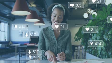 Animación-De-íconos-De-Redes-Sociales-Con-Números-Sobre-Una-Empresaria-Afroamericana-Que-Trabaja-En-La-Oficina