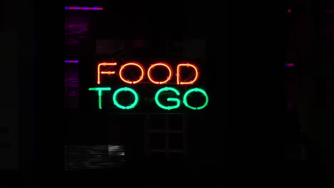 red green food to go sign glows in restaurant window, 4k
