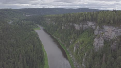 aerial view of a river cutting through a mountainous forest