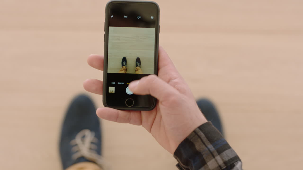 hombre usando un teléfono inteligente tomando una foto de zapatos nuevos compartiendo fotografía en las redes sociales disfrutando de la moda elegante