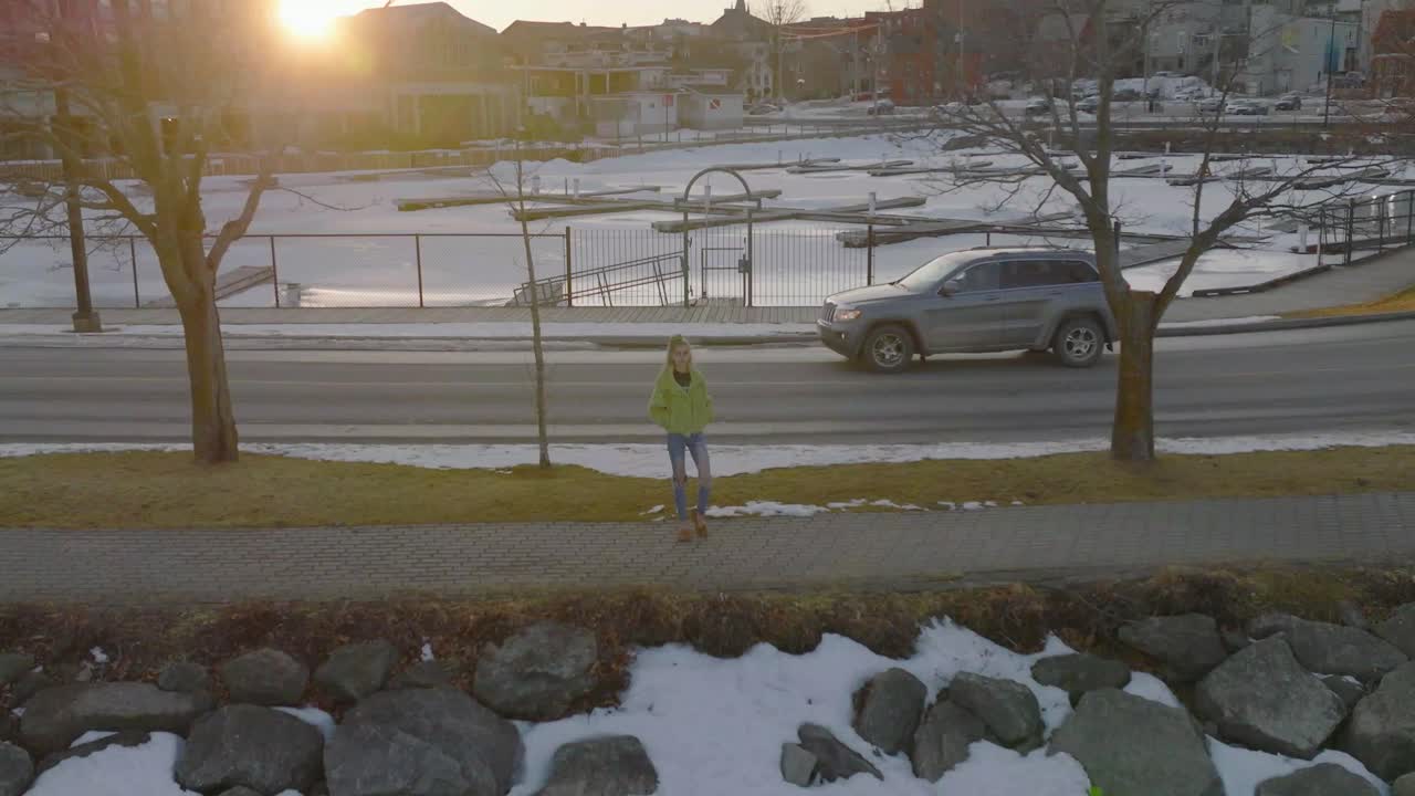 카메라를 보고 눈 공중 없이 늦은 겨울 저녁을 즐기는 젊은 여성