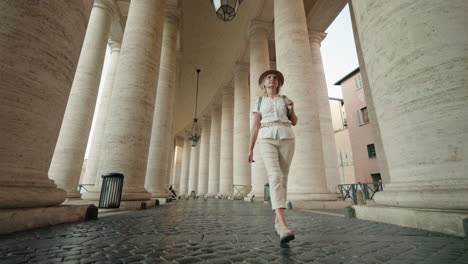 Woman walking among historical columns in Rome