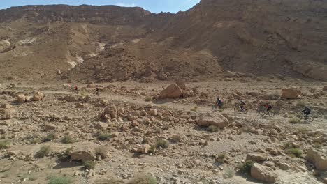 imágenes aéreas de un grupo de ciclistas que recorren senderos para bicicletas en el desierto