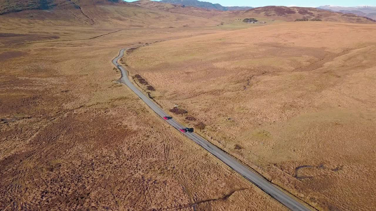 toma aérea delantera volando sobre una carretera en las tierras altas de escocia