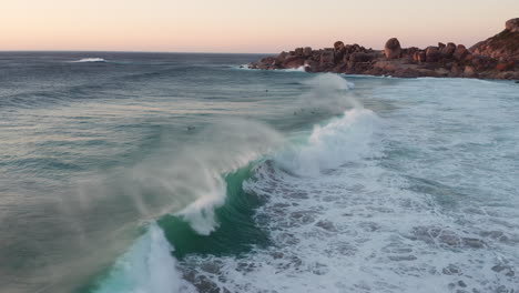 waves crashing and people swiming on the coast nearby llandudno in cape town, south africa - aerial shot