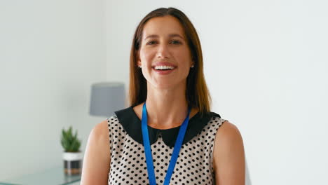 retrato de una mujer sonriente médico o médico de cabecera de pie junto al escritorio en la oficina
