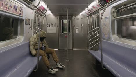 homeless man sleeping on empty subway during coronavirus outbreak