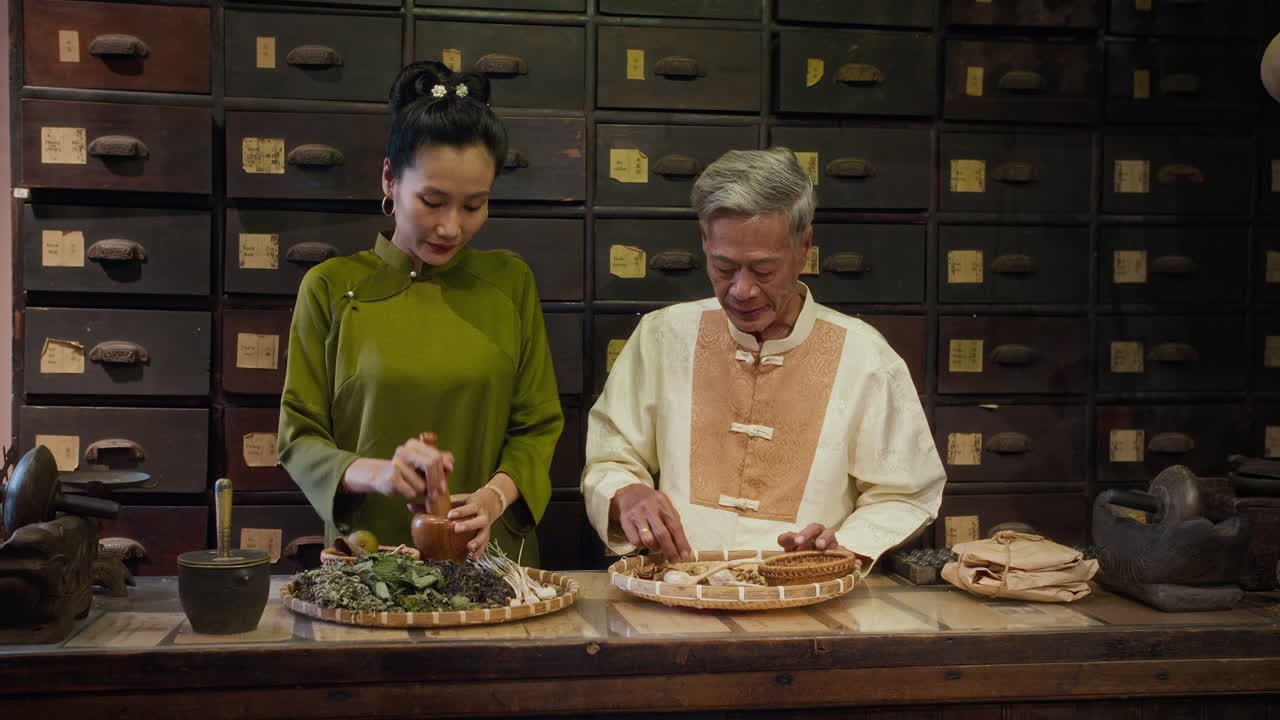 Senior Asian Father Teaching Daughter Basics of Herbal Medicine at Pharmacy