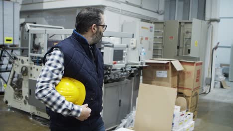 confident printing technician walking at factory