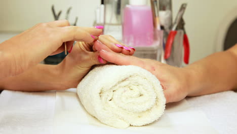 nail technician filing customers nails