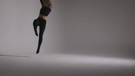 foto de estudio de longitud completa de una mujer joven haciendo práctica de baile contra fondo gris 1