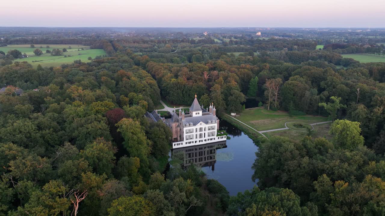 Aerial View of a Castle Surrounded by a Forest and Water