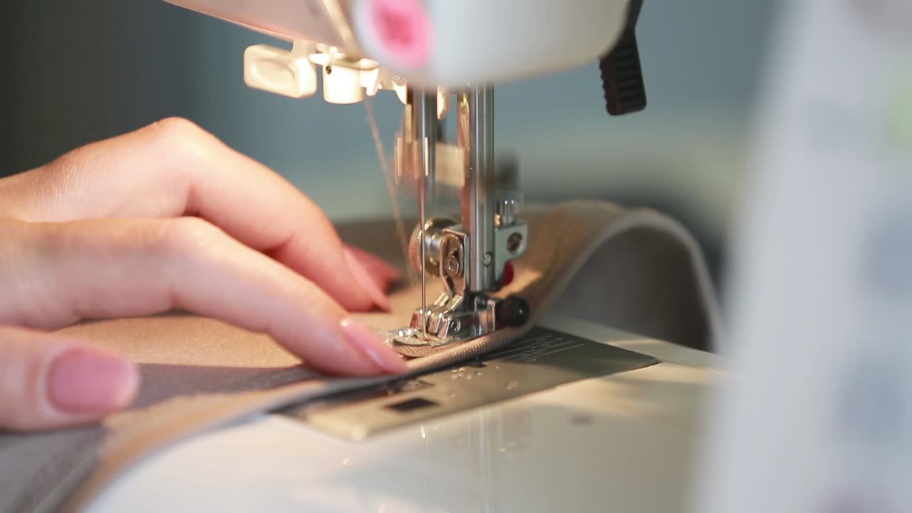 Concept of Tailoring and Making Clothes. Woman sewing clothes in the kitchen at home