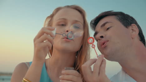 young couple blowing soap bubbles