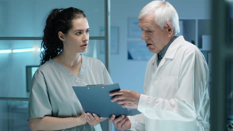 Mujer-Joven-Hablando-Con-Un-Científico-De-Laboratorio-Senior